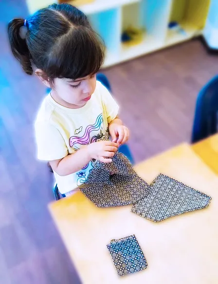 A child concentrating on purposeful Montessori work.